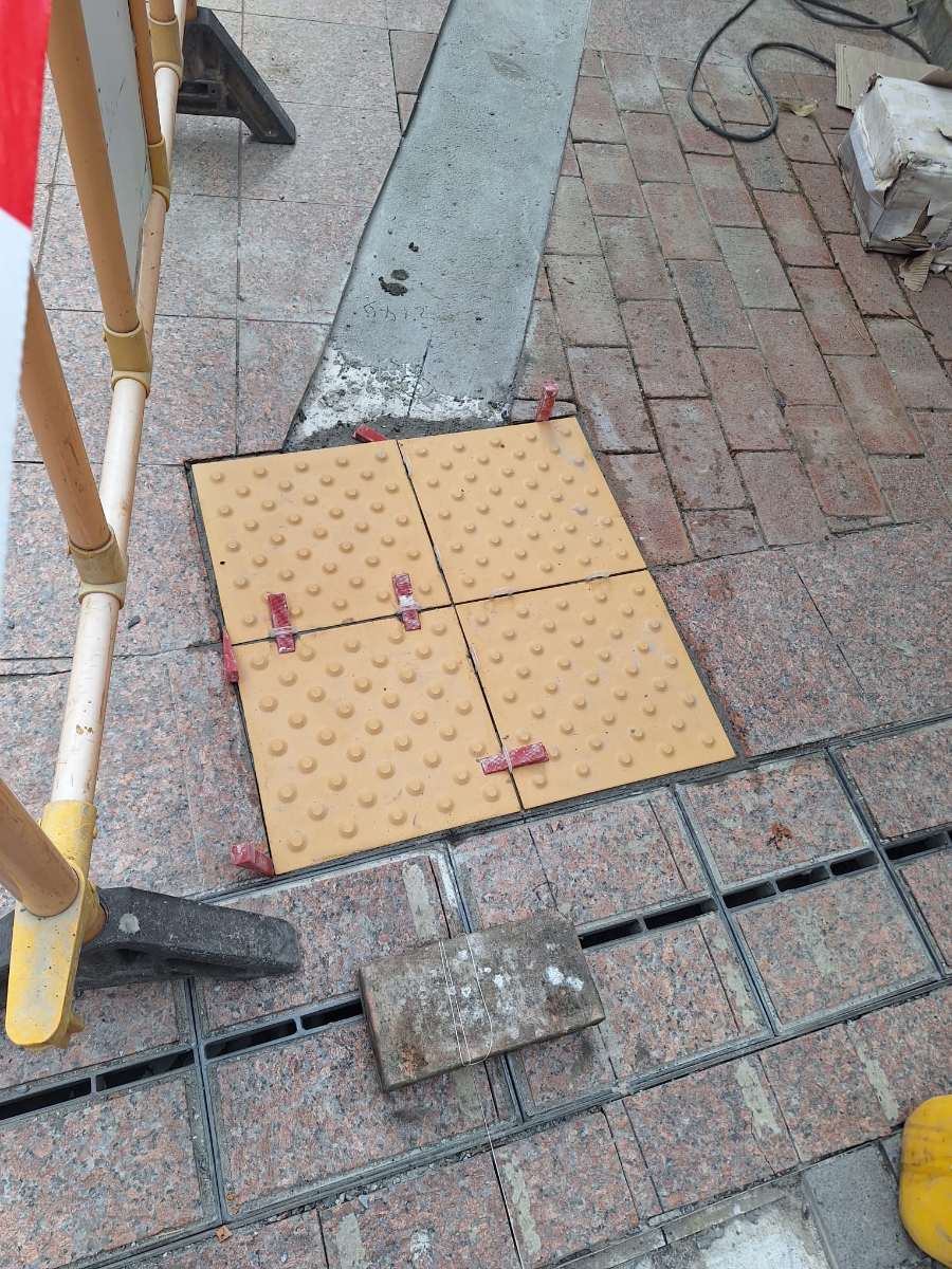 施工中：四塊細圓點位置磚以紅色膠楔控制磚縫（交貨鋪設作品）