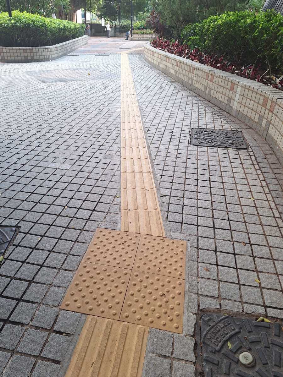 轉角以 2×2 細圓點位置磚定位，嵌入灰色細方塊麻石地面（交貨鋪設作品）